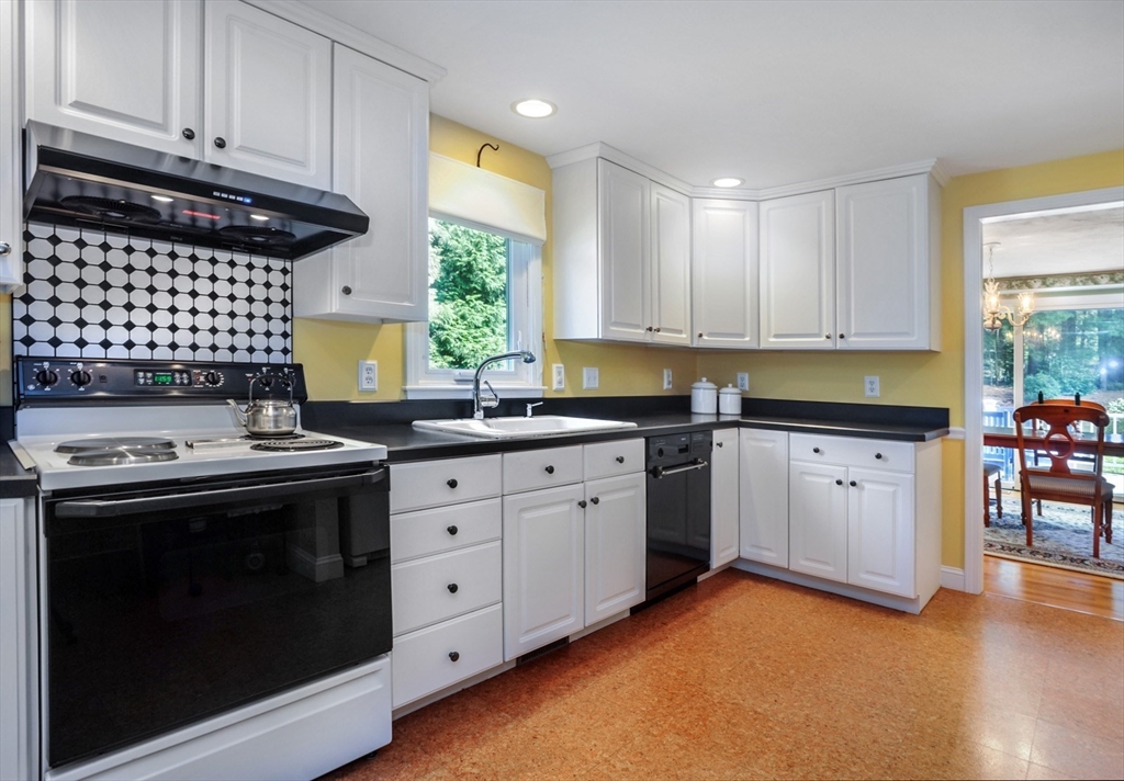 56 Bay Farm Road, Unit 56 Duxbury, MA 02332 - Photo 7 of 20 a kitchen with granite countertop a stove sink and cabinets