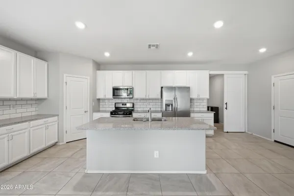 a large kitchen with stainless steel appliances lots of counter top space