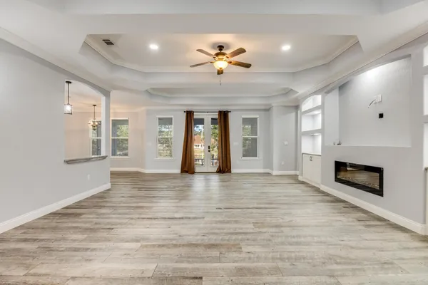 a view of empty room with window and wooden floor