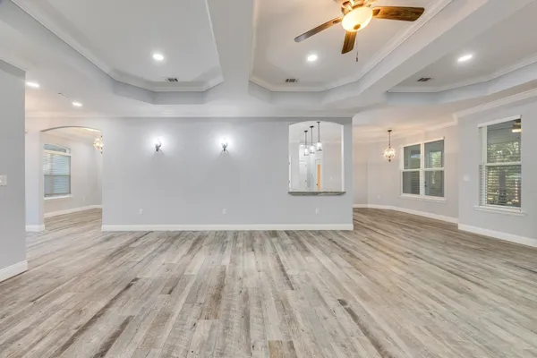 a large kitchen with kitchen island a stove a sink a center island and wooden floor