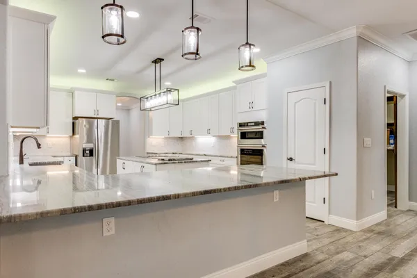 a kitchen with granite countertop white cabinets and sink