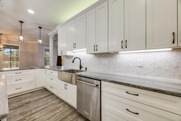 a view of an empty room and window a ceiling fan and wooden floor