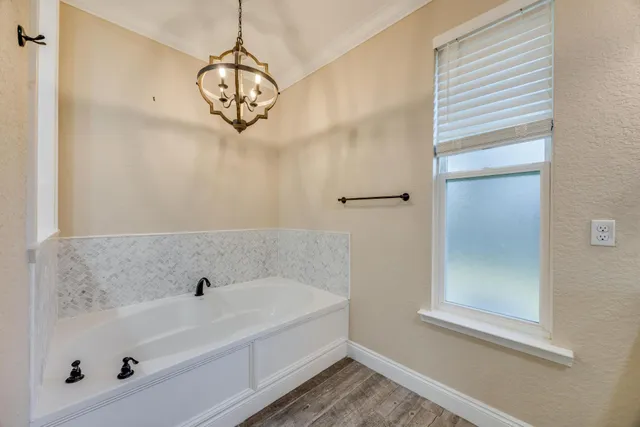 an aerial view of a house with a yard and large tree