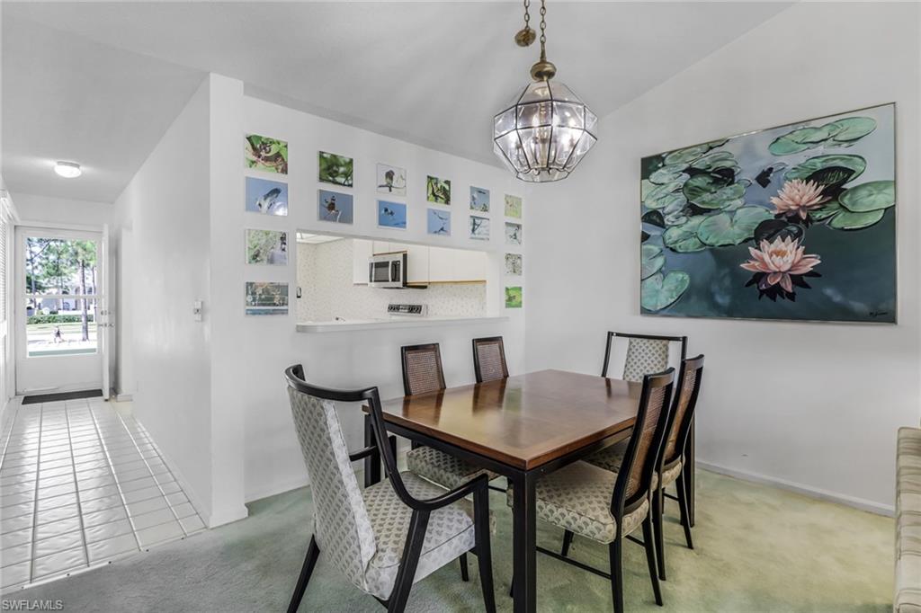 780 Augusta Boulevard, Unit C204 Naples, FL 34113 - Photo 11 of 40 a view of a dining room with furniture and chandelier