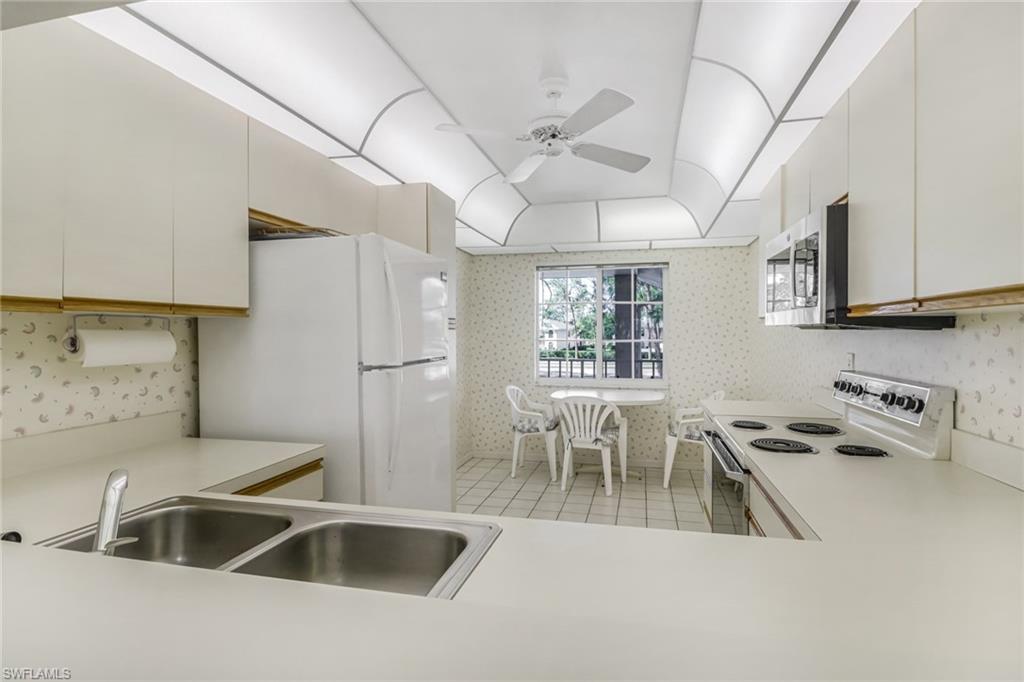780 Augusta Boulevard, Unit C204 Naples, FL 34113 - Photo 15 of 40 a kitchen that has a table and chairs in it