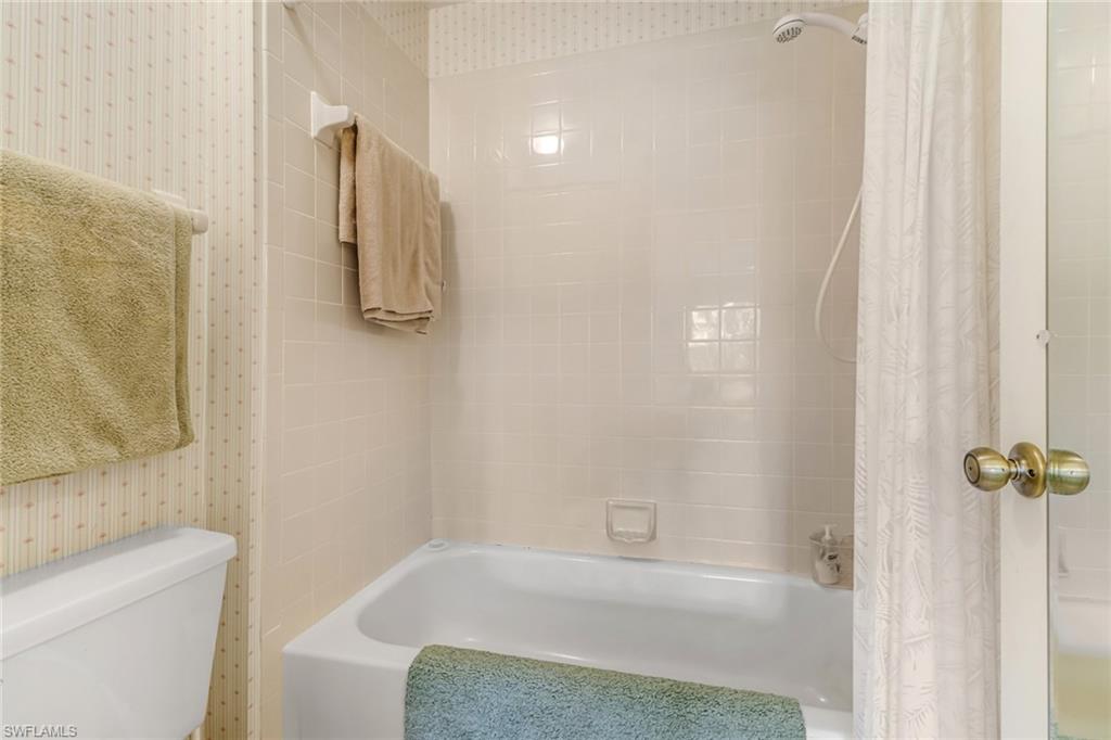 780 Augusta Boulevard, Unit C204 Naples, FL 34113 - Photo 19 of 40 a bathroom with a bathtub and shower