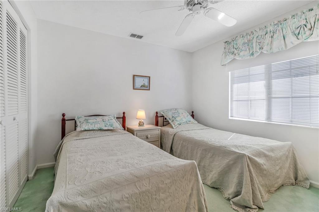 780 Augusta Boulevard, Unit C204 Naples, FL 34113 - Photo 22 of 40 a bedroom with two beds and a window
