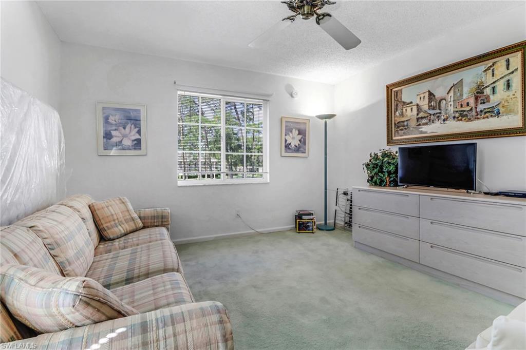 780 Augusta Boulevard, Unit C204 Naples, FL 34113 - Photo 25 of 40 a living room with furniture and a flat screen tv