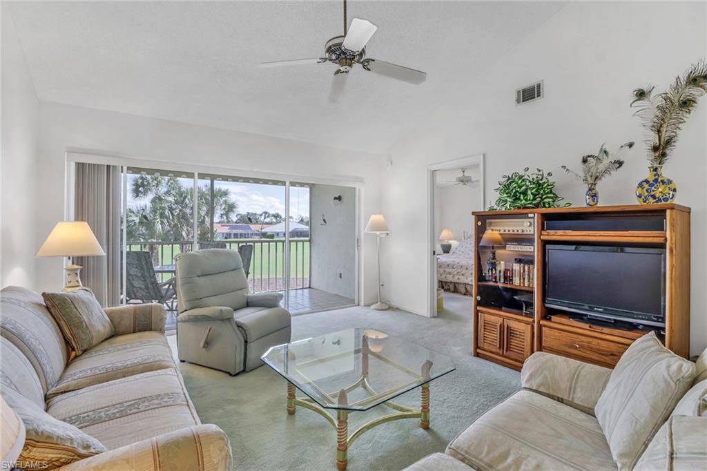 780 Augusta Boulevard, Unit C204 Naples, FL 34113 - Photo 7 of 40 a living room with furniture ceiling fan and a flat screen tv