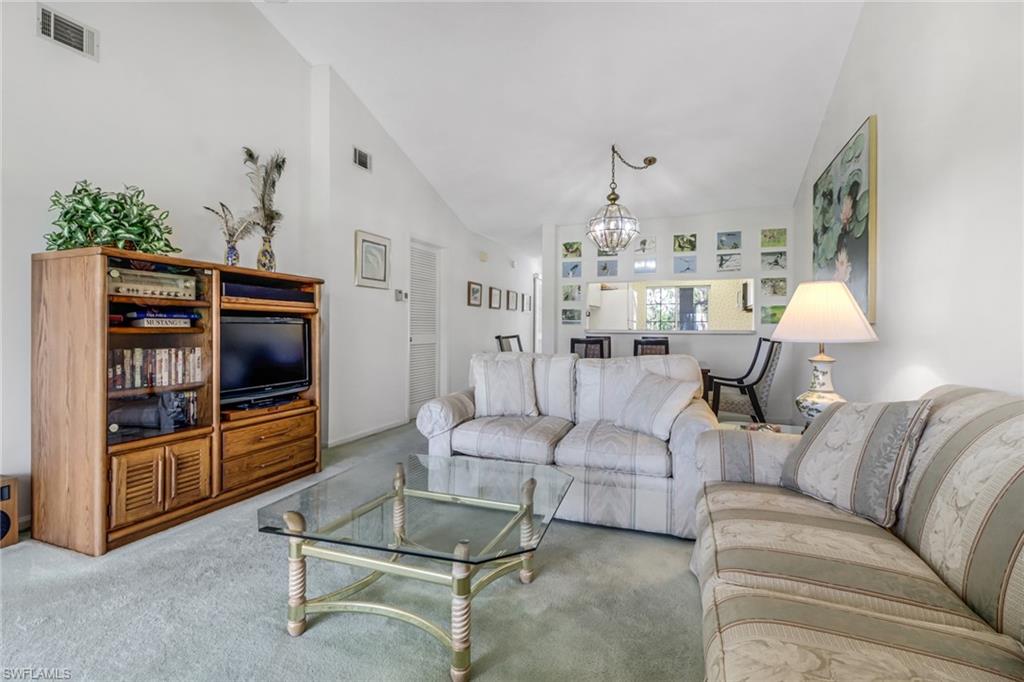 780 Augusta Boulevard, Unit C204 Naples, FL 34113 - Photo 8 of 40 a living room with furniture and a flat screen tv