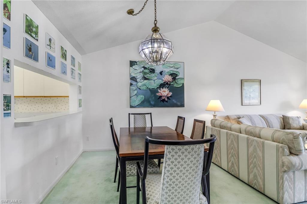 780 Augusta Boulevard, Unit C204 Naples, FL 34113 - Photo 9 of 40 a dining room with furniture a rug and a chandelier
