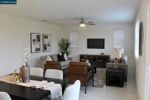 a living room with furniture a flat screen tv and a window