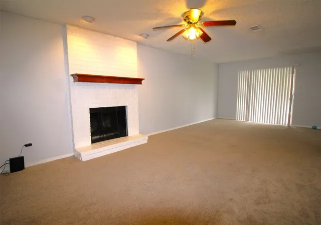 a view of empty room with fireplace and fan