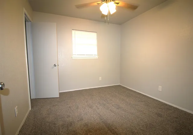an empty room with a chandelier fan