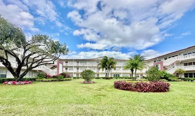 a view of a house with a big yard and large trees