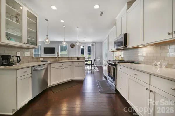 a kitchen with granite countertop white cabinets and stainless steel appliances