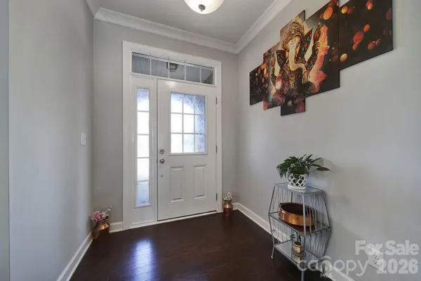 an entryway with wooden floor and front door