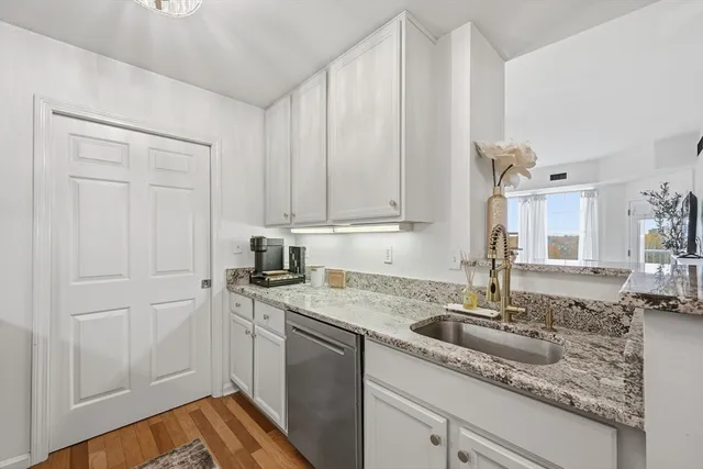 a kitchen with stainless steel appliances granite countertop a sink a stove and cabinets