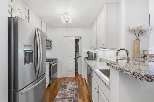 a kitchen with stainless steel appliances granite countertop a refrigerator and a sink