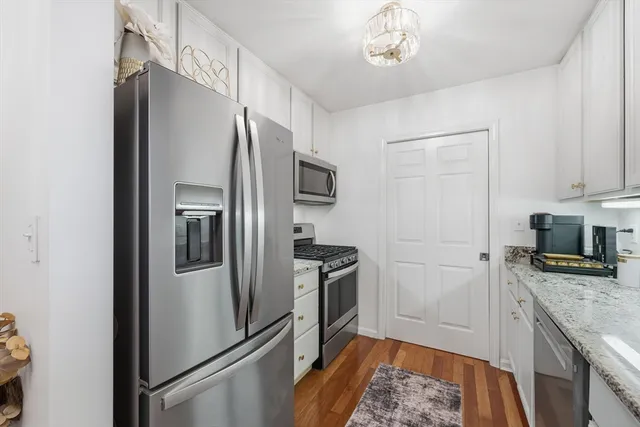 a kitchen with stainless steel appliances granite countertop a refrigerator and a stove top oven