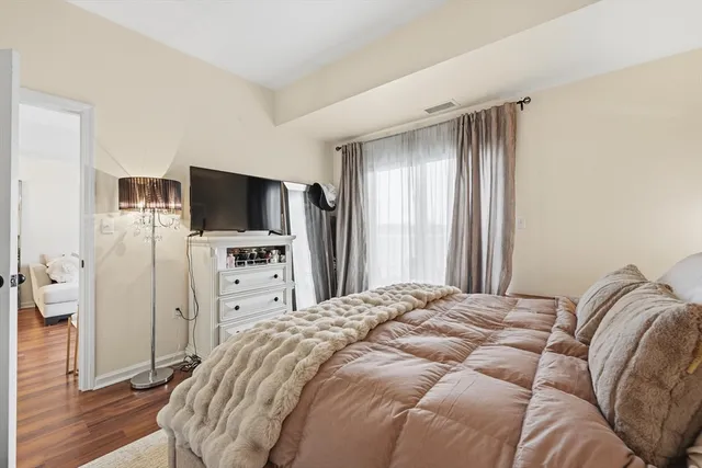a spacious bedroom with a bed and a flat screen tv