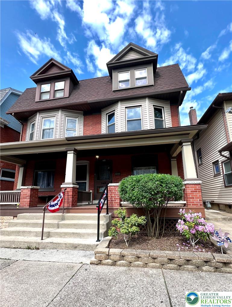 A classic brick exterior with bay windows and a welcoming front porch offers timeless curb appeal.
