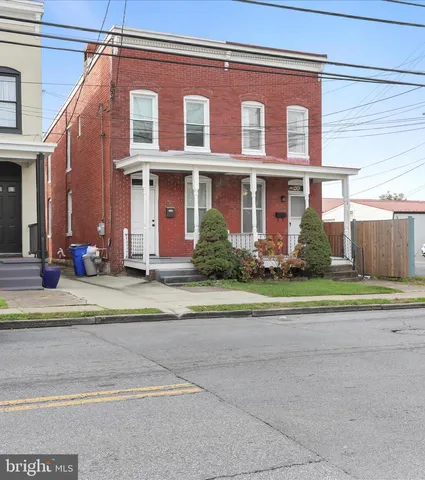 a view of a brick house next to a yard