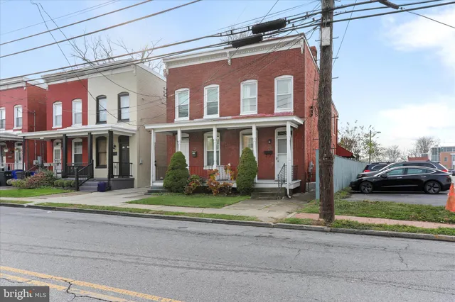 front view of a brick house next to a yard