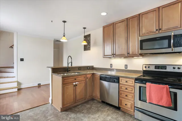 a kitchen with stainless steel appliances granite countertop a sink a stove and a granite counter tops