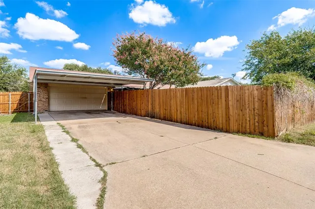 a view of backyard with wooden fence