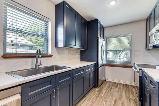 a kitchen with a sink a window and cabinets