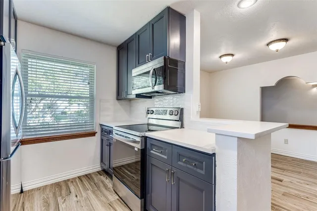 a kitchen that has a sink a stove and a microwave