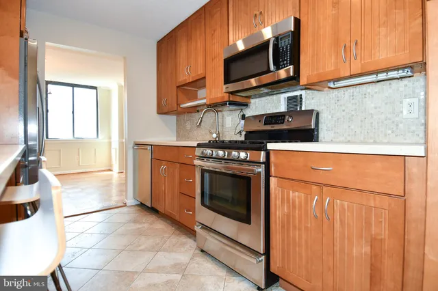 a kitchen with stainless steel appliances granite countertop a stove microwave and sink