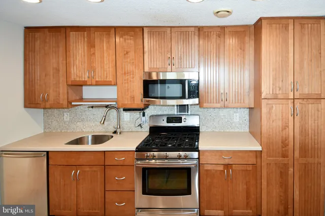 a kitchen with a sink cabinets and a stove top oven