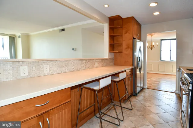 a kitchen with stainless steel appliances a refrigerator and a counter space