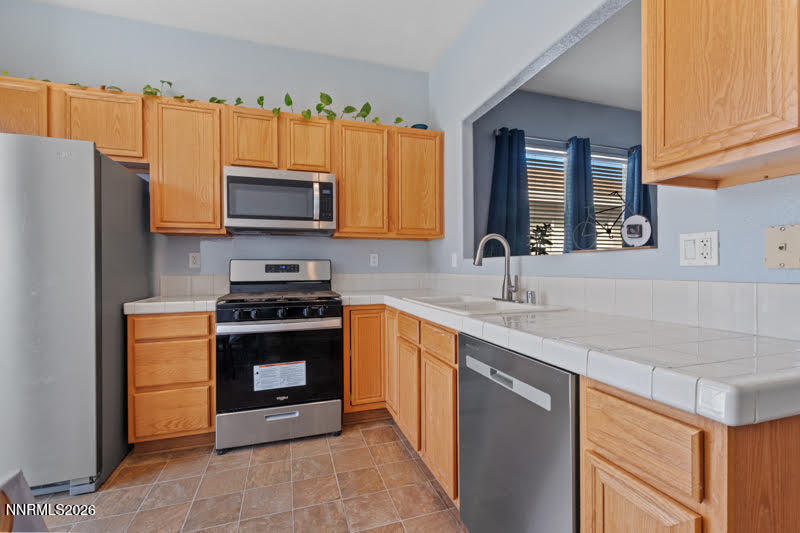 10025 Hampton Park Drive Reno, NV 89521 - Photo 12 of 16 a kitchen with stainless steel appliances granite countertop a stove a sink and a microwave