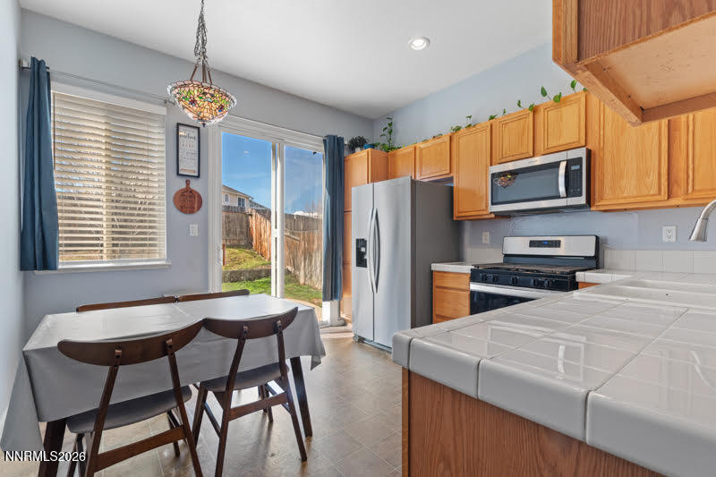 10025 Hampton Park Drive Reno, NV 89521 - Photo 13 of 16 a kitchen with stainless steel appliances wooden floor dining table and chairs