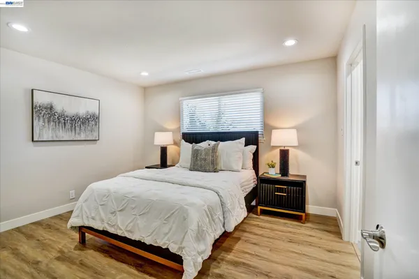 a bedroom with a bed and wooden floor