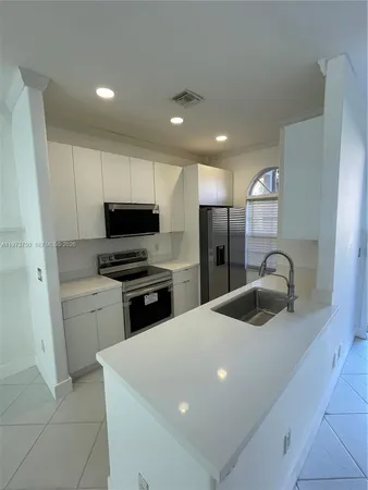 a kitchen with sink cabinets and refrigerator