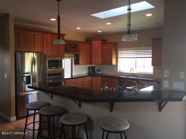 307 Warrior Road Yakima, WA 98901 - Photo 5 of 38 a kitchen with a table chairs refrigerator and microwave