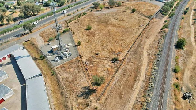 a view of a dry yard with wooden fence