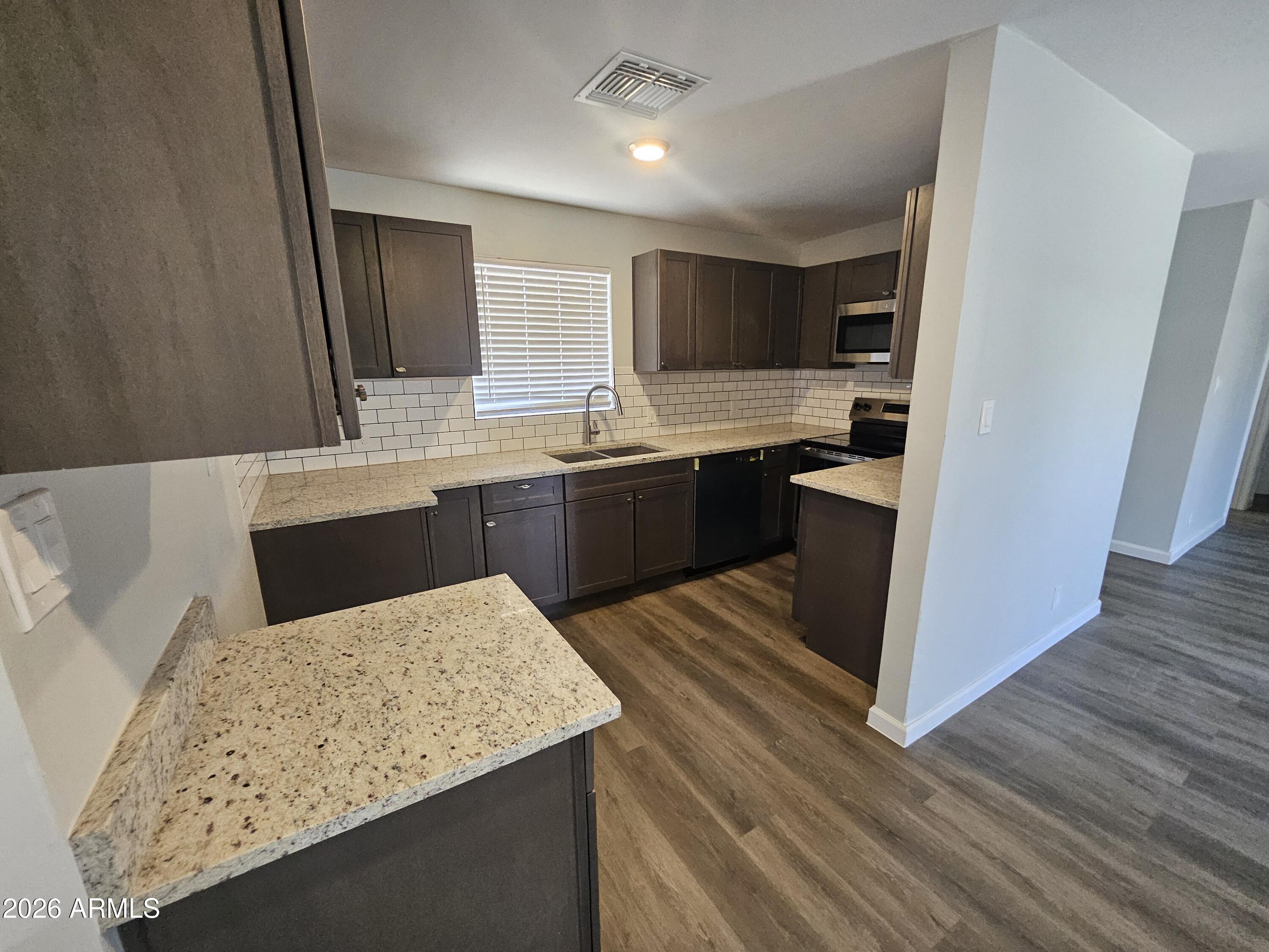524 West 3rd Place Mesa, AZ 85201 - Photo 3 of 23 a large kitchen with kitchen island a sink dishwasher stove and wooden cabinets