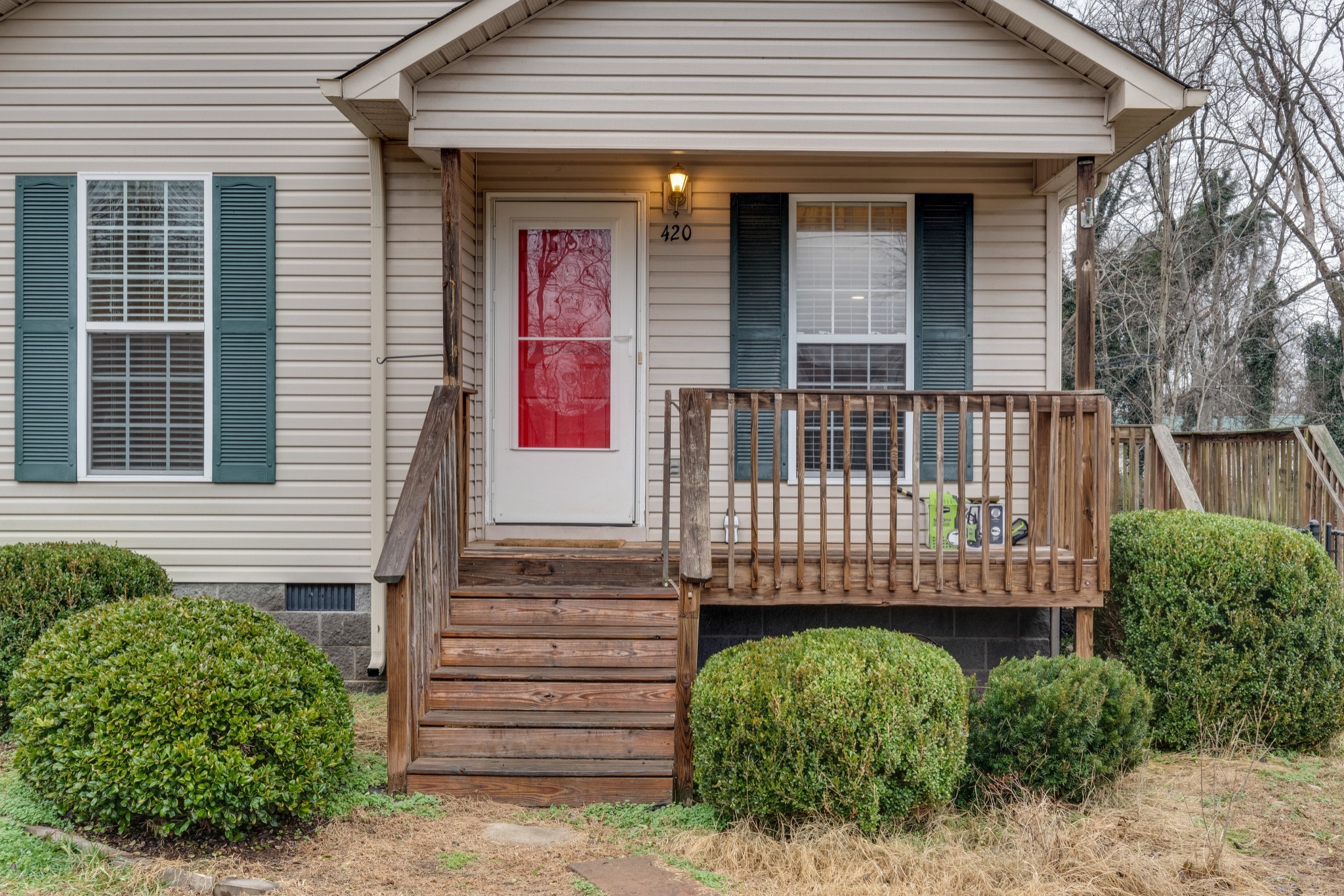 a view of a house with a small yard and wooden floor and fence