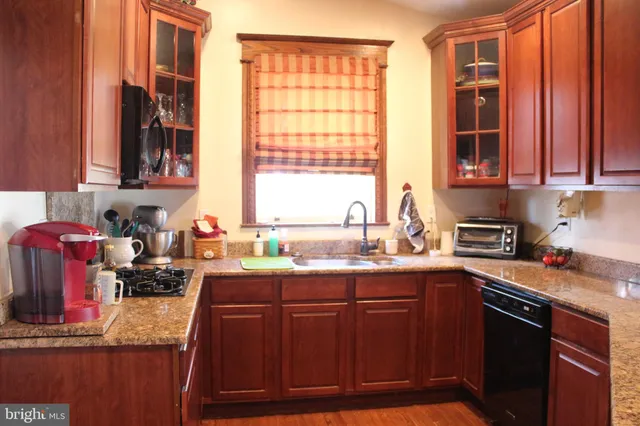 a kitchen with stainless steel appliances granite countertop a sink stove and cabinets