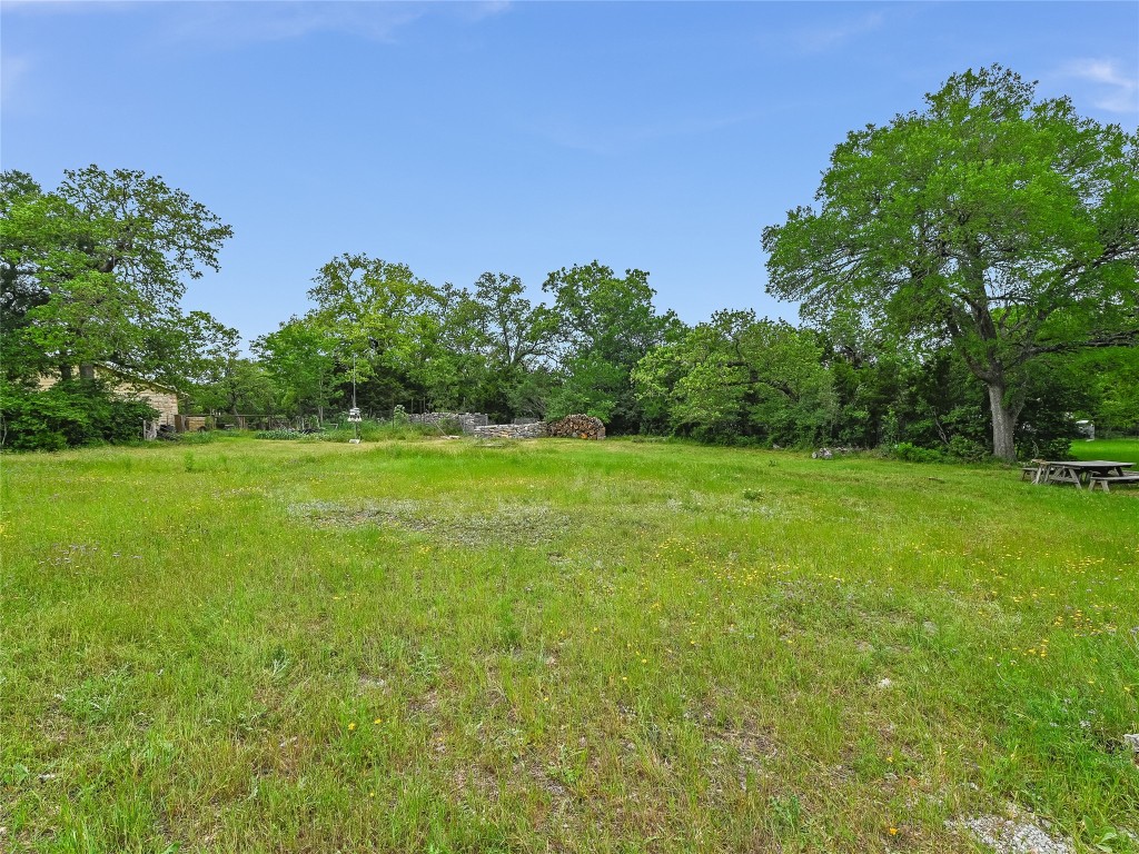 a yard with lots of green space and trees in the background