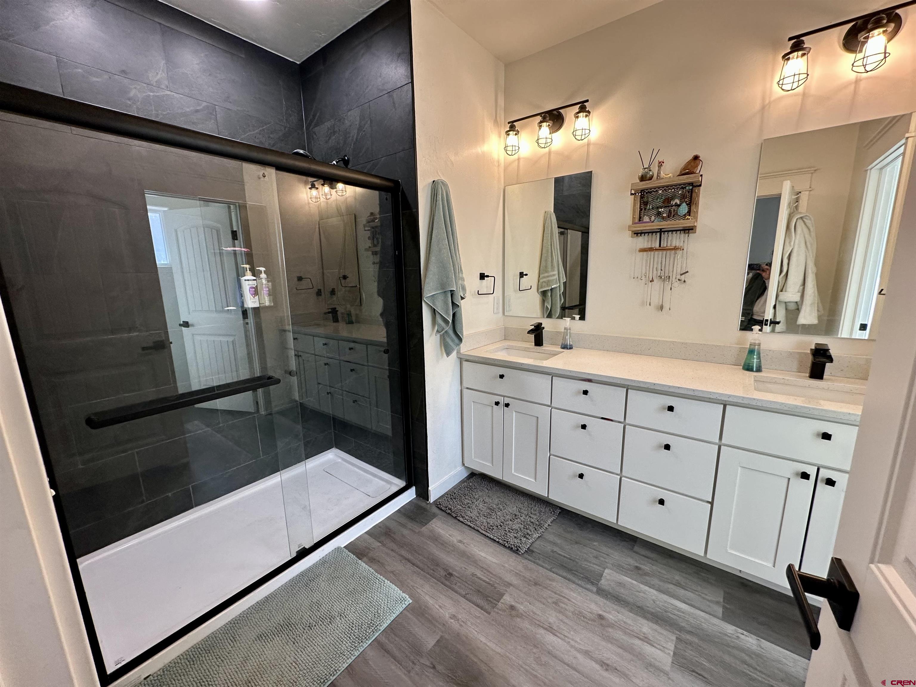 471 River Valley Court Delta, CO 81416 - Photo 17 of 31 a spacious bathroom with a double vanity sink a large mirror and shower