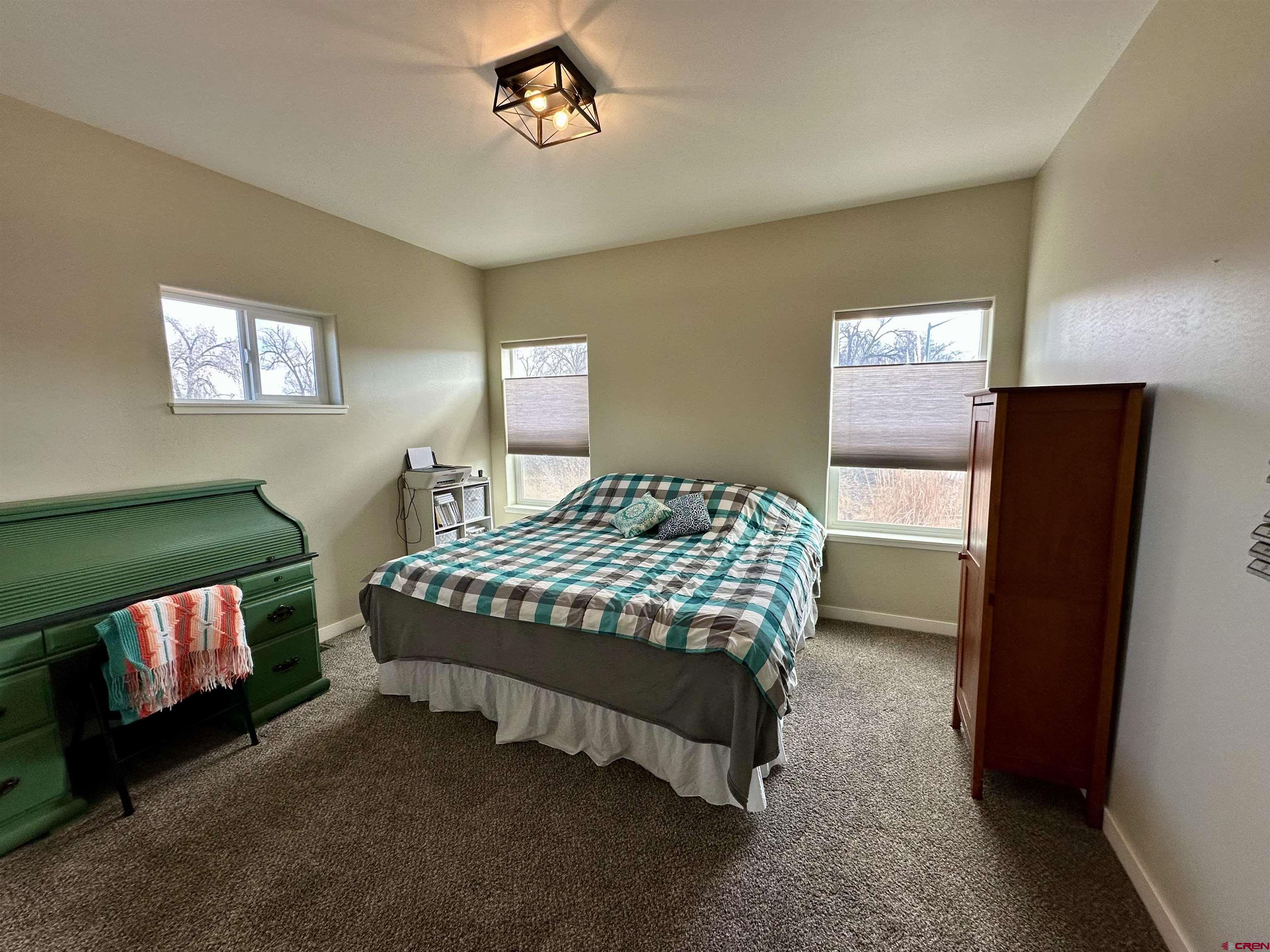 471 River Valley Court Delta, CO 81416 - Photo 20 of 31 a bedroom with a bed and a chandelier