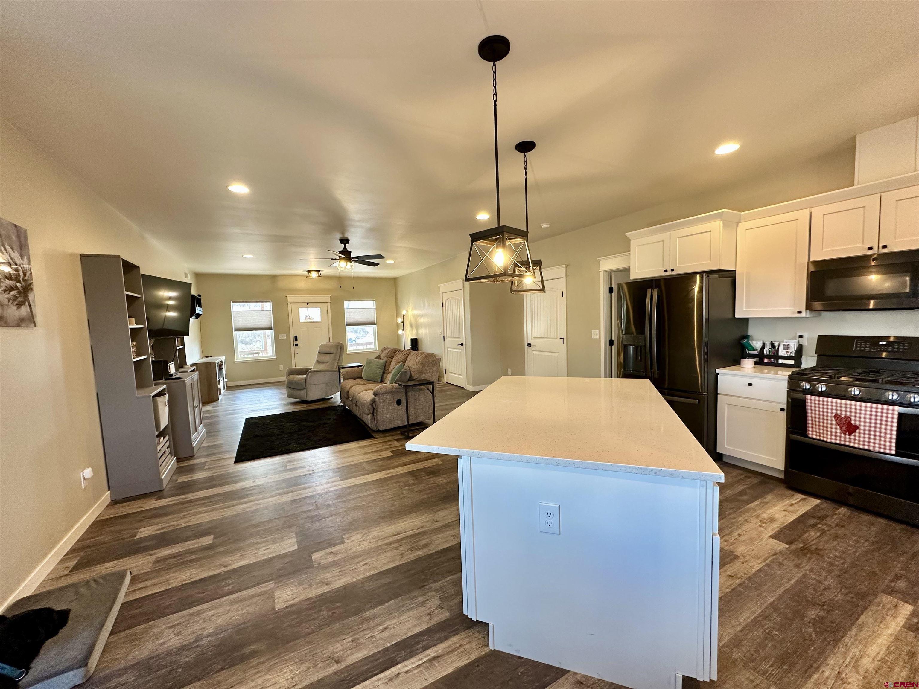 471 River Valley Court Delta, CO 81416 - Photo 9 of 31 a large kitchen with stainless steel appliances kitchen island granite countertop a refrigerator a stove and a sink with wooden floor