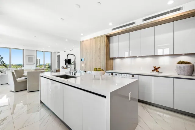 a kitchen with stainless steel appliances granite countertop a sink dishwasher stove and white cabinets with wooden floor