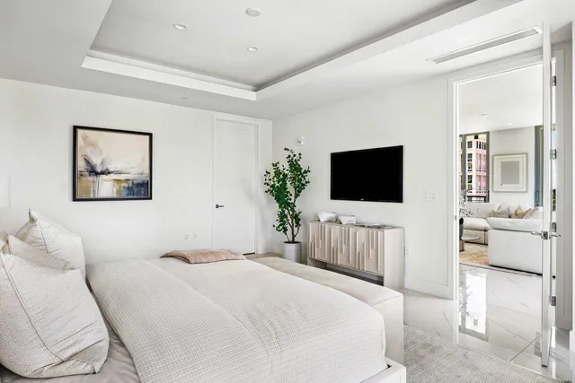 a bedroom with a bed tv on the wall and a window